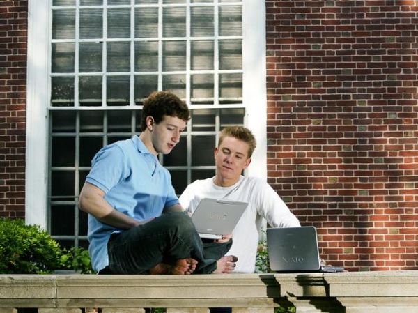 2004年5月，扎克伯格和克里斯·休斯（Chris Hughes）在哈佛大学艾略特楼（Eliot House）前。扎克伯格在Facebook发展初期找来了哈佛同学休斯，并从休斯那里获得对刚起步的社交网络服务的意见。
